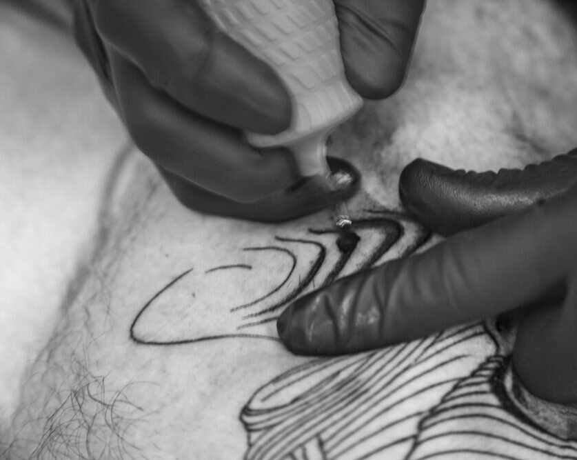 Tattoo artist hands with machine at Mannly Tattoos